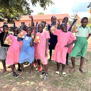 SAG Kit Distribution image showing Butabula Primary School girls receiving 107 kits in Kabukye, Uganda on Aug 9, 2024