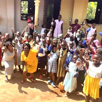SAG Kit Distribution image showing Divine Primary School girls receiving 200 kits in Dambwe, Uganda on Dec 8, 2024