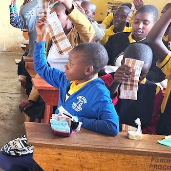 SAG Kit Distribution image showing Mukora Primary School girls receiving 97 kits in Mbarara, Uganda on Mar 18, 2025