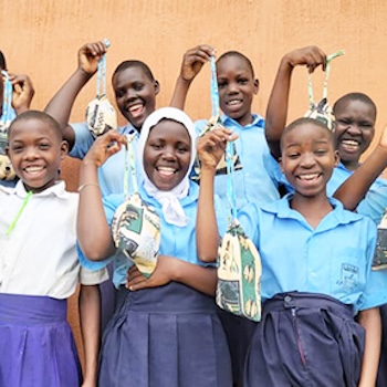SAG Kit Distribution image showing Nyimbwa Primary School girls receiving 75 kits in Luwero, Uganda on Oct 8, 2025