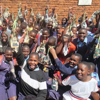 SAG Kit Distribution image showing Kibanga Primary School girls receiving 150 kits in Kalagala, Uganda on Mar 12, 2026