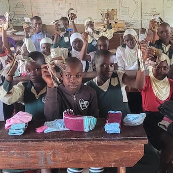 SAG Kit Distribution image showing Busiika Umea Primary School girls receiving 52 kits in Busiika, Uganda on May 26, 2026